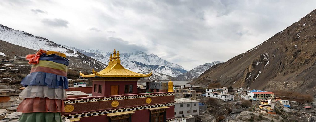 Tibetan monastery with golden roof in Himalayan mountain village.