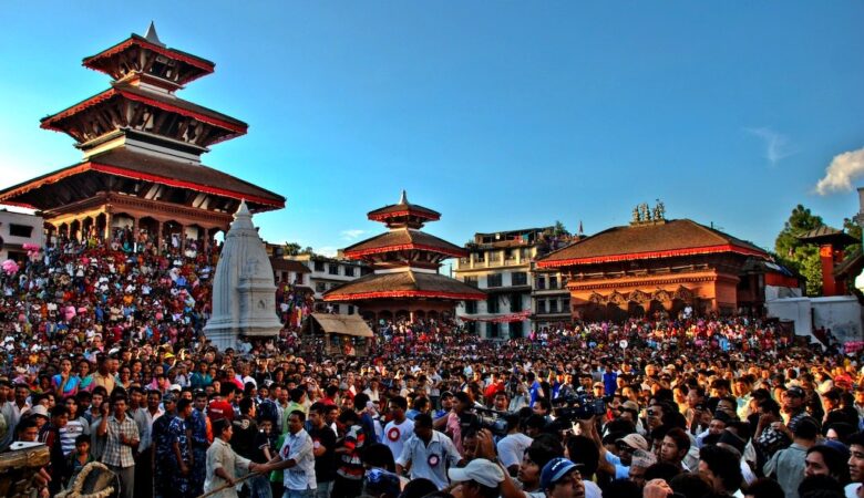 Large crowd gathered in Kathmandu Durbar Square surrounded by pagoda-style temples and a central stupa during a cultural festival.