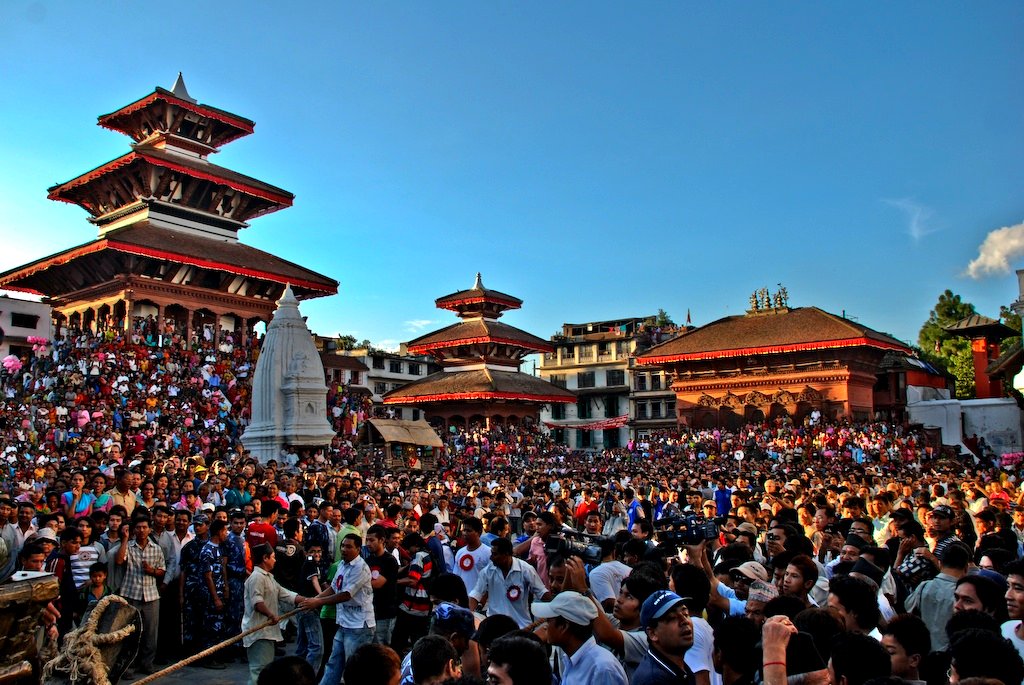 Large crowd gathered in Kathmandu Durbar Square surrounded by pagoda-style temples and a central stupa during a cultural festival.