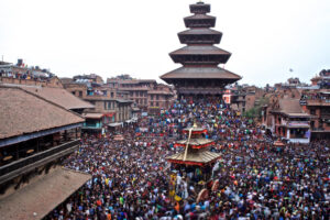 Crowd at Nyatapola Temple with decorated chariot during festival in Bhaktapur.