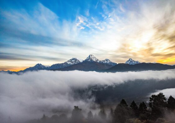 Himalayan mountains glowing at sunrise with clouds below