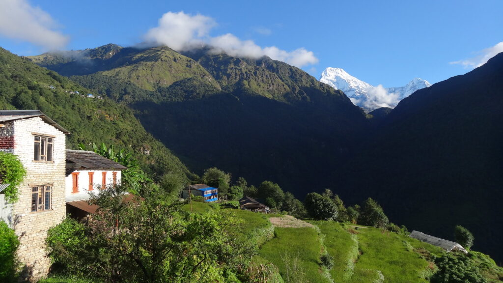 Himalayan village with terraced fields and mountain backdrop