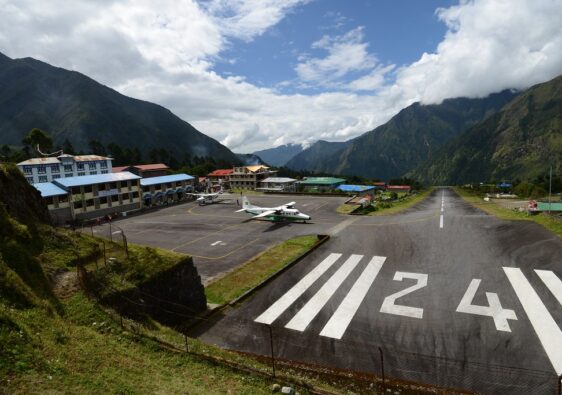 “High‑altitude Himalayan airport with short sloped runway and small aircraft”