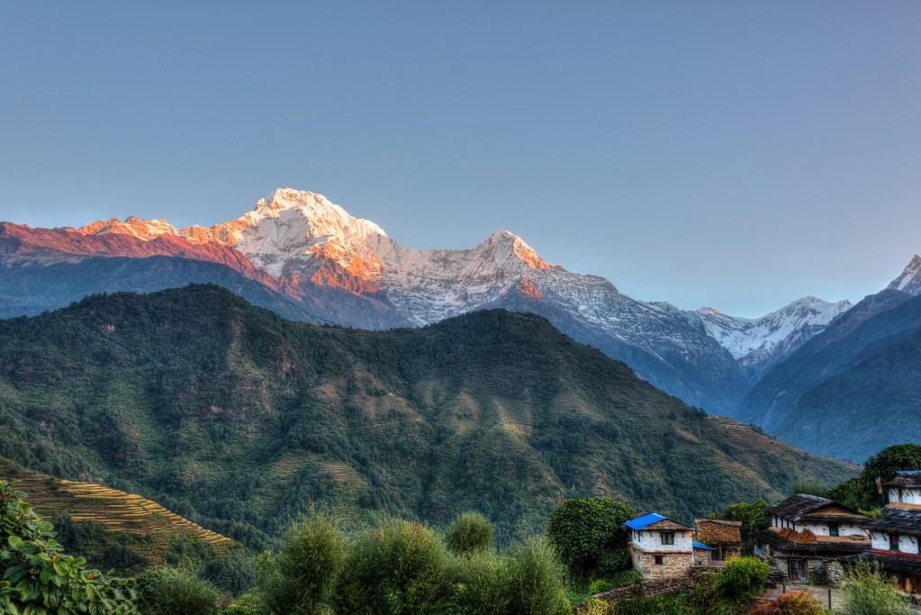 Himalayan sunrise over snowy peaks and terraced village